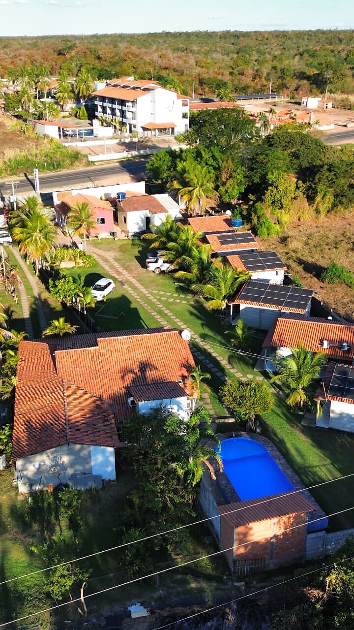 Vista aérea panorâmica do Sítio Dhelta: chalés, piscina, jardim e o cerrado piauiense ao redor